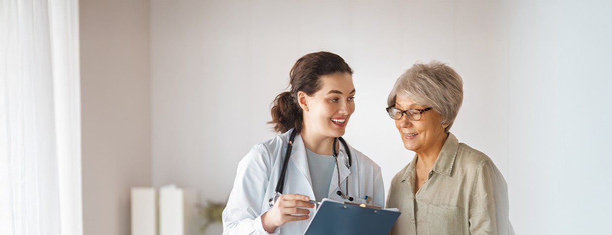 Doctor and patient discussing, with the doctor holding a clipboard.